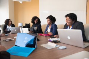 Create Engaging Course Videos: A group of women is laughing while looking at their laptops and each other